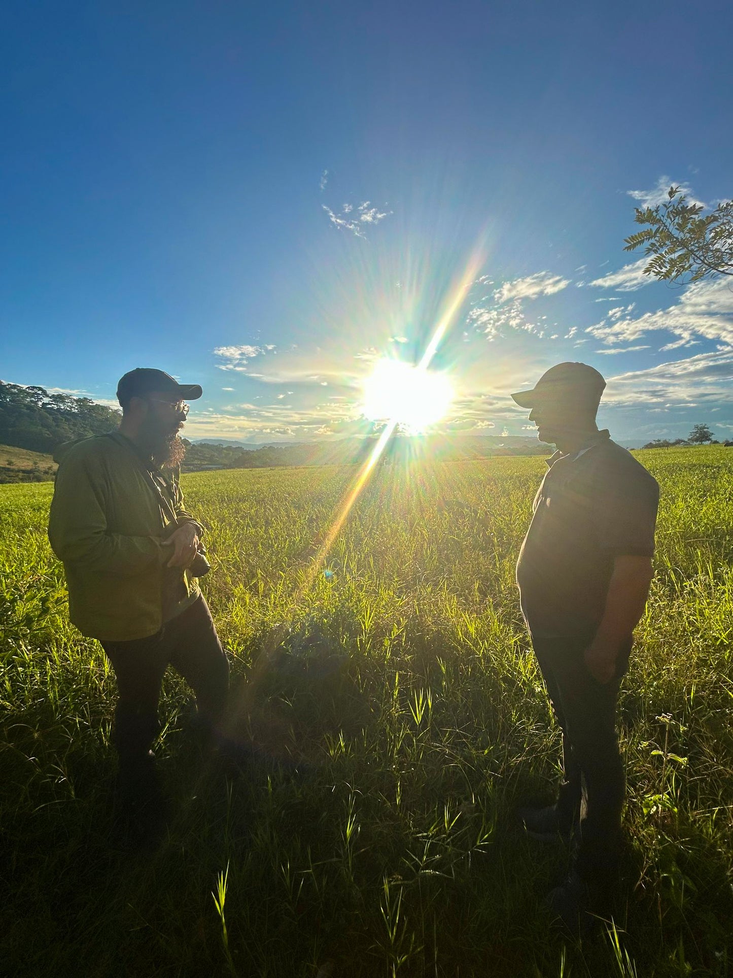 Danny Castrellon and Nelson Cruz standing in a field with the sun shining brightly