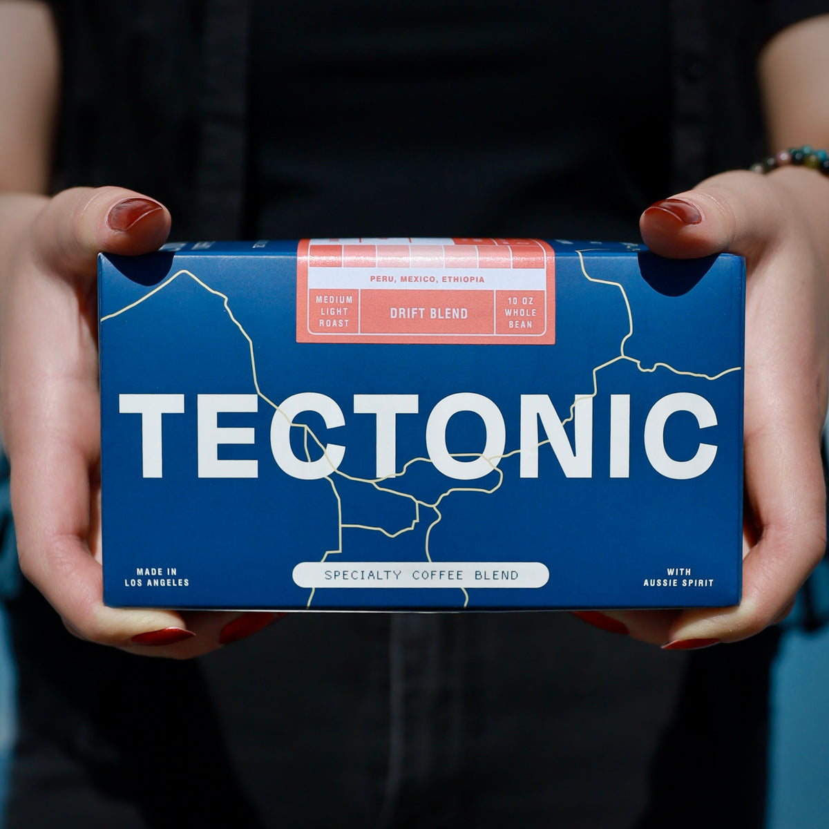 Tectonic Coffee Drift Blend 10oz box held in two hands; whole bean packaging shown