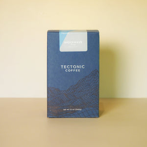 Blue Tectonic Coffee box on a beige surface with a beige background