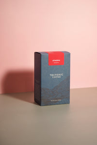 Tectonic Coffee box with a red label on a pink background