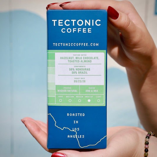 Tectonic Coffee packaging held in two hands; illustrative rotating subscription coffee varies by delivery