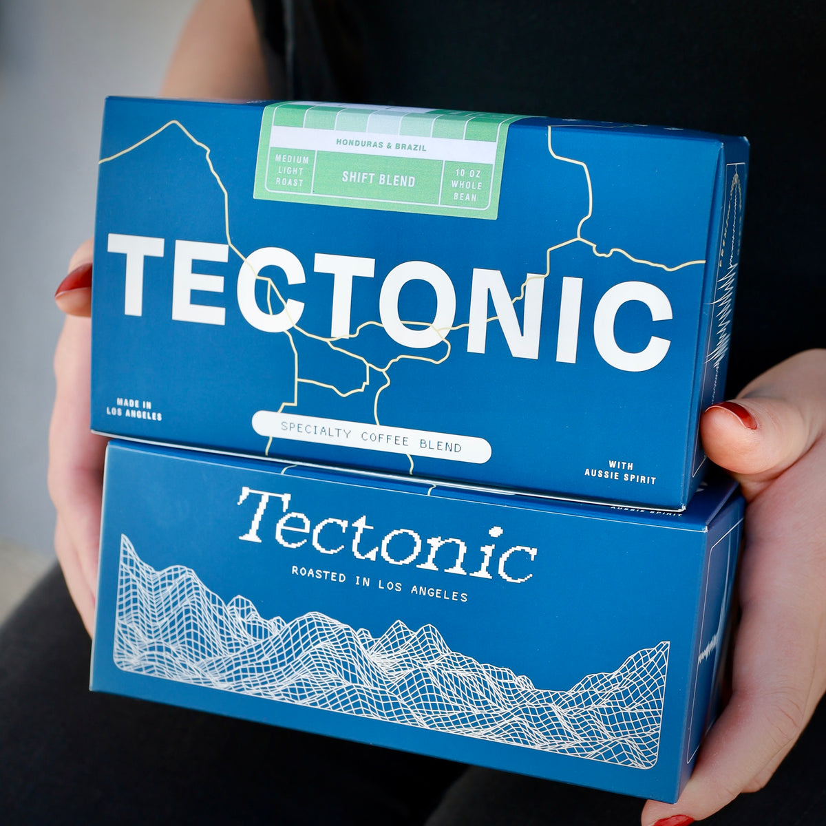 Tectonic Coffee Shift Blend 10oz box above a second blue Tectonic box; whole bean packaging shown